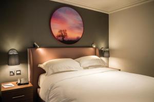 克努斯福德科腾斯酒店及Spa的一间卧室设有一张床和一个圆形的窗户。