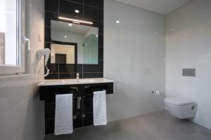 劳林哈Vale de Lourinhã - Casas de Campo的一间带水槽、卫生间和镜子的浴室