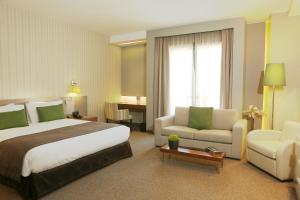 贝鲁特公园塔套房酒店的大型酒店客房,配有床和沙发