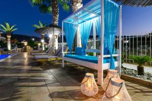 玛利亚Stelios Gardens的露台凉亭配有蓝色窗帘