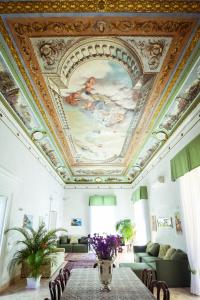 那不勒斯NapoliMia Boutique Hotel的客厅设有天花板和绘画