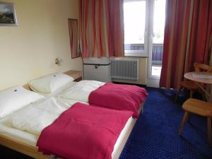 Tauplitzalm伯格霍夫陶普利匝尔酒店的酒店客房的床铺配有红色和白色的床单
