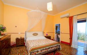 圣安吉洛里加利度假酒店的卧室配有一张床铺,位于一个黄色墙壁的房间