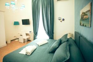 那不勒斯NapoliMia Boutique Hotel的一间卧室配有蓝色的床和两个枕头