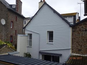 圣马洛L'Escale en Bretagne的灰色的房子,有窗户和砖砌建筑