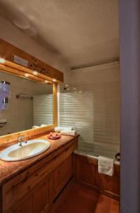 里蒙纽耶佩尔武酒店的浴室配有盥洗盆、镜子和浴缸