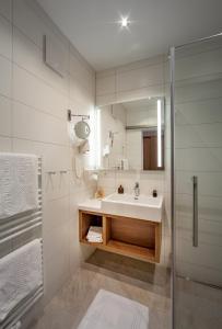 因斯布鲁克乎贝霍夫酒店的白色的浴室设有水槽和淋浴。