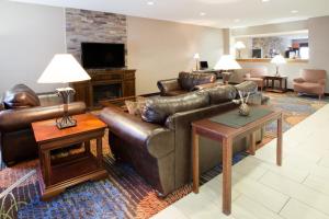 奥本Baymont by Wyndham Auburn的客厅配有真皮沙发和桌子