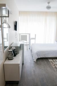 派尔努Pärnu Apartment的一间卧室配有一张床和一张带电话的书桌