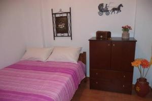 法拉萨纳Kavousi Traditional Home的一间卧室配有一张床和一个带紫色毯子的梳妆台。