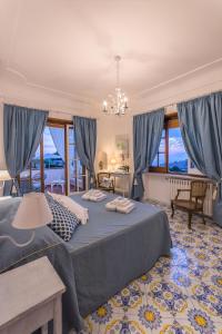 阿纳卡普里B&B Villa Cristina的一间卧室配有大床和蓝色窗帘