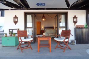 蒂亚斯Casa Berriel 1的庭院配有三把椅子、一张桌子和一张桌子
