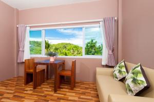涛岛阁道岛绿茵度假酒店的带沙发、桌子和窗户的客厅