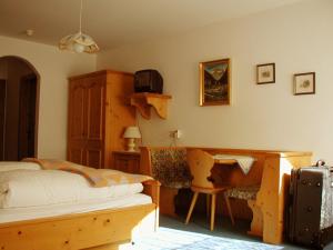 布伦纳山口附近马特赖斯托尔茨酒店的一间卧室配有一张床、一张桌子和一把椅子