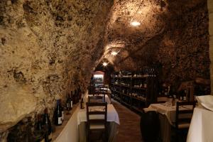 瓜尔迪亚格雷莱B&B Dei Raselli的洞穴内的品酒室,配有桌子和葡萄酒瓶