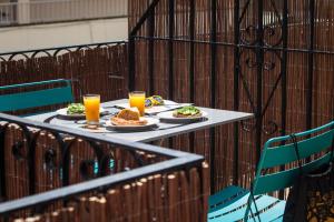 伊维萨镇Ten Hostel的一张桌子,上面放着两盘食物和两杯橙汁