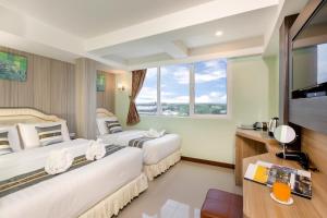 莱卡邦RoomQuest Suvarnabhumi Airport Romklao Soi 6的配有大窗户的酒店客房内的两张床