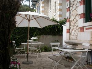 滨海圣帕莱弗瑞沃别墅酒店的庭院内桌椅和遮阳伞
