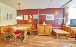 萨尔巴赫Appartements Alpin的配有木制家具和电视的用餐室