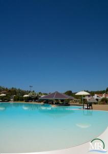 阿尔盖罗Residence Hotel Monte Ricciu的一座带遮阳伞的大型蓝色游泳池