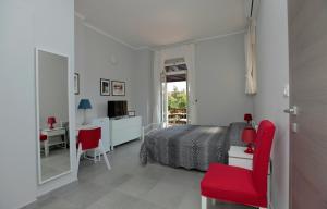 都灵Albergo San Maurizio的一间卧室配有一张床和一张带红色椅子的书桌