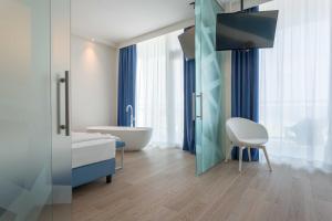 索托马里纳梅迪特拉内奥酒店的一间带浴缸的浴室和一台电视。