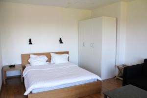 隆德Place Lund Studios的一间卧室配有一张带白色床单的床和橱柜。