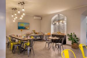 罗马城市花园酒店 的用餐室配有桌子和黄色椅子