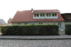 格赖夫斯瓦尔德Ferienwohnung-zur-Klosterruine-Eldena的白色的房子,有红色的屋顶和树 ⁇ 