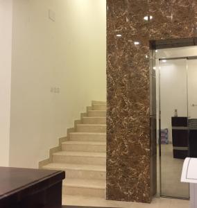 艾卜哈Al Sondos Furnished Apartments的一间设有大理石墙的房间的楼梯