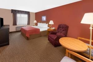 圣伊尼亚斯圣伊格纳斯速8酒店的配有床、椅子和桌子的酒店客房