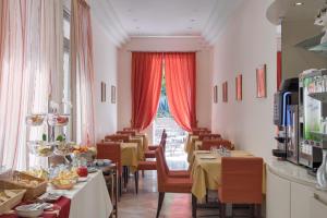 梅斯特加里波第酒店的餐厅设有桌椅和窗户。