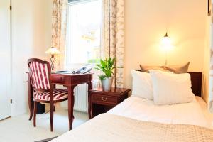 穆尔舍Hotell Björkhaga的一间卧室配有一张床、一张桌子和一把椅子