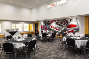 哈迪港科瓦利拉斯酒店的用餐室配有桌椅和壁画