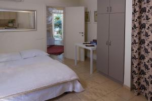 罗什平纳Pinat Nofesh的一间卧室配有一张床、一张桌子和一个窗户。