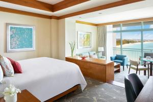 拿骚The Cove at Atlantis的酒店客房设有一张床、一张书桌和一间客厅。