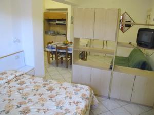 伊斯基亚Aparthotel Villa Marinù的一间卧室配有一张床,并在一间客房内配有电视。