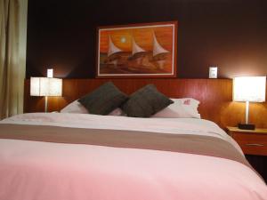 圣保罗布瑞妮高级公寓酒店的一间卧室配有一张大床和两盏灯