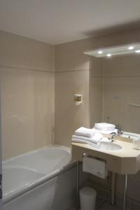 莱萨布勒-多洛讷Hôtel SABLES D'O et son restaurant LE 16 BIS的浴室配有盥洗盆、浴缸和镜子