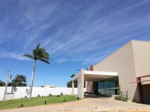 古鲁皮Hotel Jequitibá的一座白色的建筑,前面有棕榈树