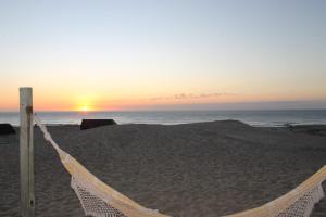 德尔迪阿布罗角Arenas del Mar的海滩上的吊床,背靠日落