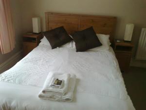 伯恩茅斯金斯利酒店的一张带毛巾的白色床和托盘