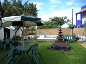 瓦兹特佩克Hotel Ocampo的桌椅、雨伞和喷泉