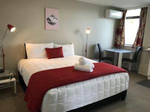 奥玛鲁奥玛鲁阿斯科特汽车旅馆的一间卧室配有一张带红白毯子的床