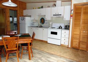 拉马巴耶Oasis du grand fond Inc的厨房配有白色家电和桌椅