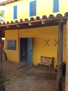 伊塔乌纳斯Arte Vida Hostel的前面有长凳的黄色房子