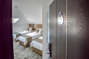 萨拉热窝萨拉热窝门赫里塔吉酒店的客房设有两张床和一个带两张床的衣柜。