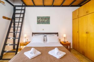 锡蒂亚Romanza Villas的一间卧室配有带2条白色毛巾的床