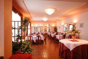 PremenoHotel Villa Rosy的用餐室配有带白色桌布的桌子