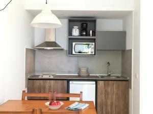 克里斯托港Ses Gavines-Cala Anguila Apartments的厨房配有木桌和水槽。